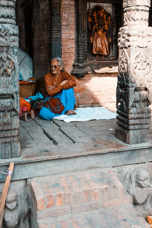 a woman sits on the steps next to a statue