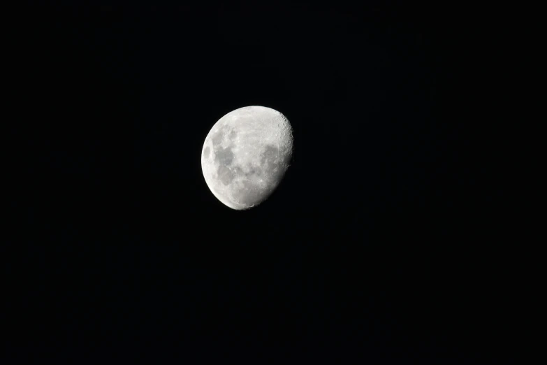 a half moon in the sky above dark skies