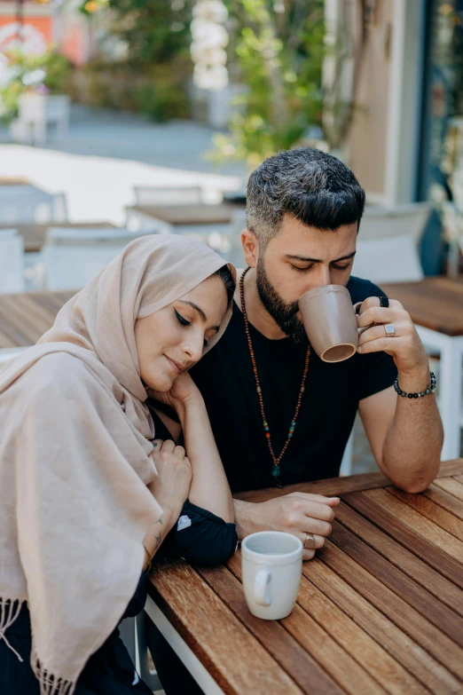 two people sitting at a table drinking coffee