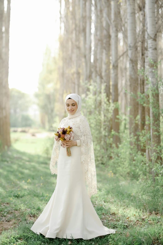 a woman is standing in the middle of some tall trees