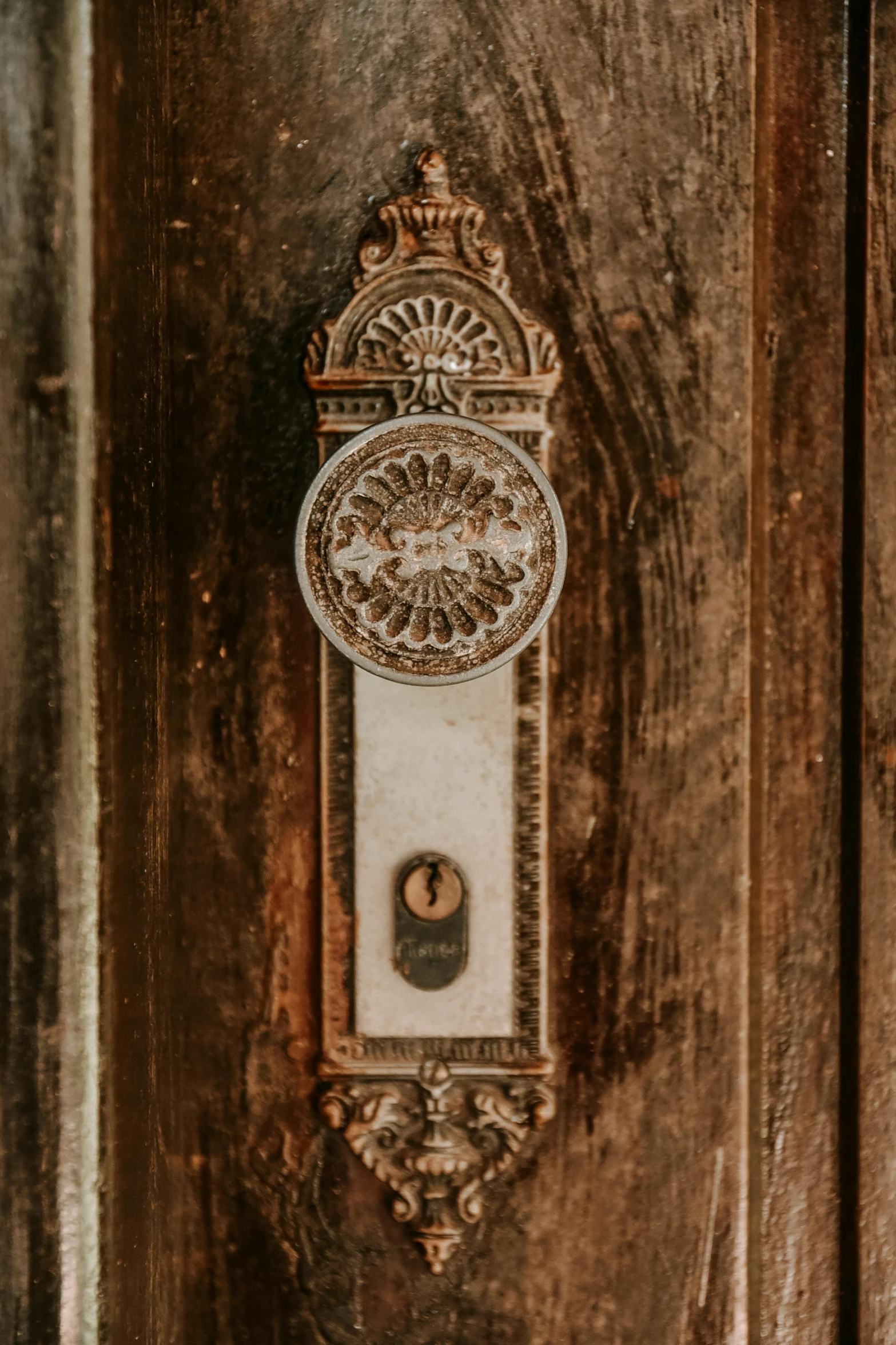 a brown wood door with a metal decorative clock