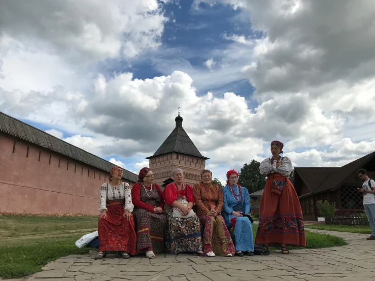 a group of people in costumes sit on chairs