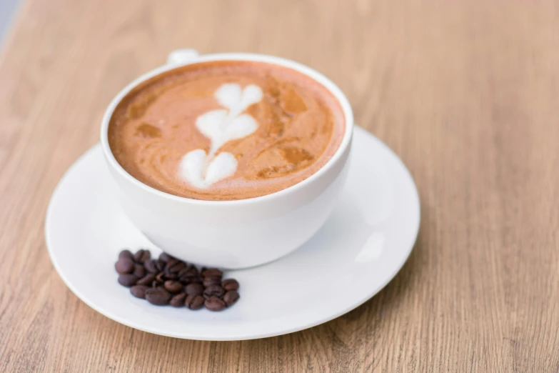 a close up of a cup of coffee with hearts on top