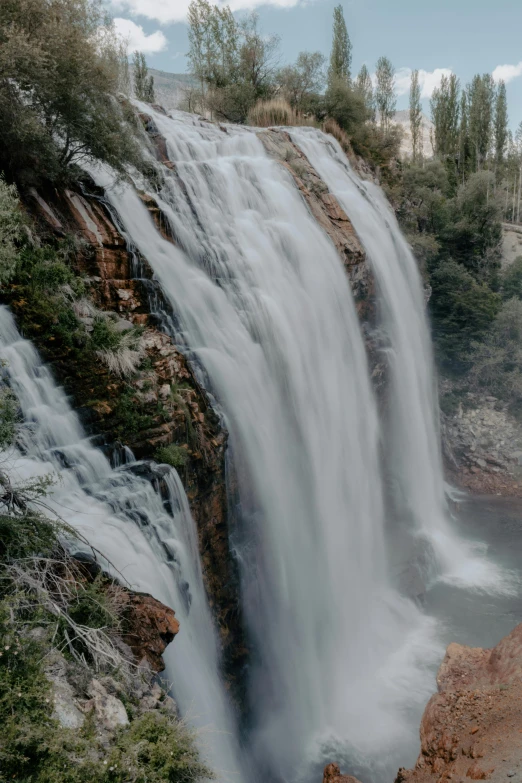 waterfall with a horse statue at the bottom