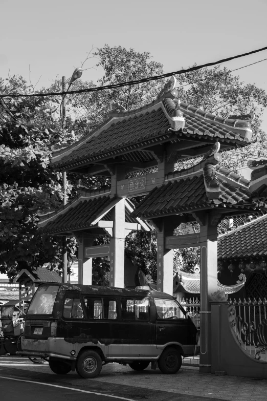 black and white po of two vans parked under an oriental style gazebo