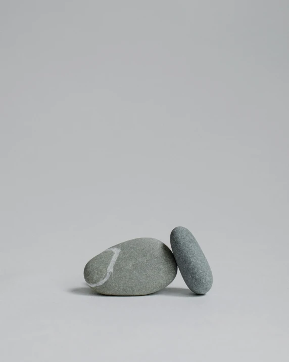 two rocks sitting next to each other, one of which has been balanced on top