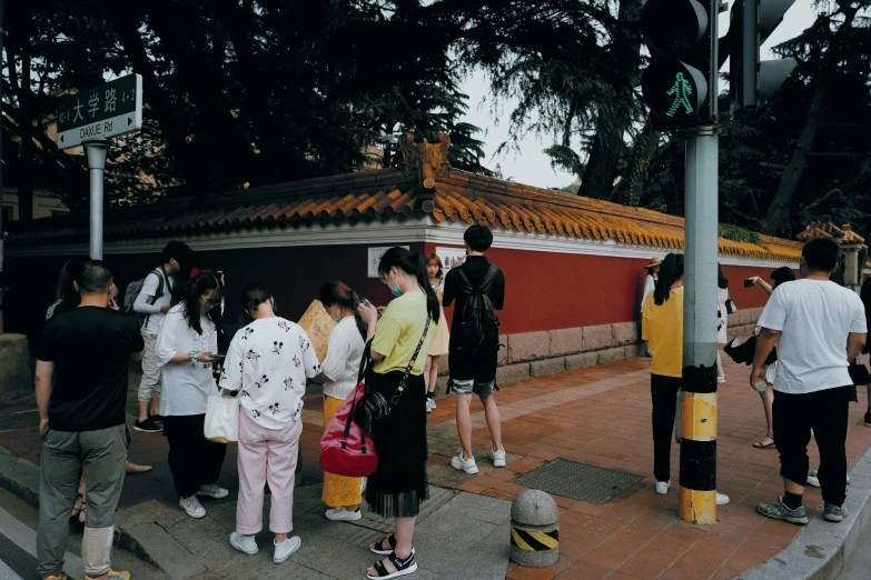 a group of people waiting at an asian temple