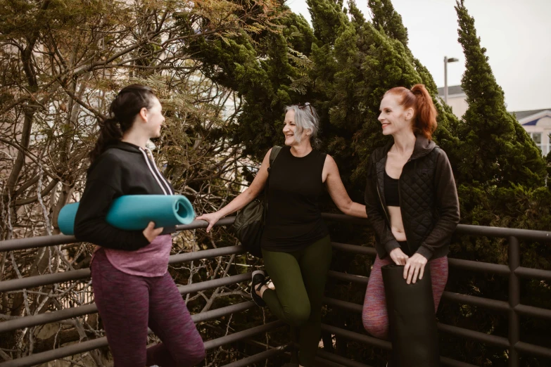 women stand on top of the railing and are laughing