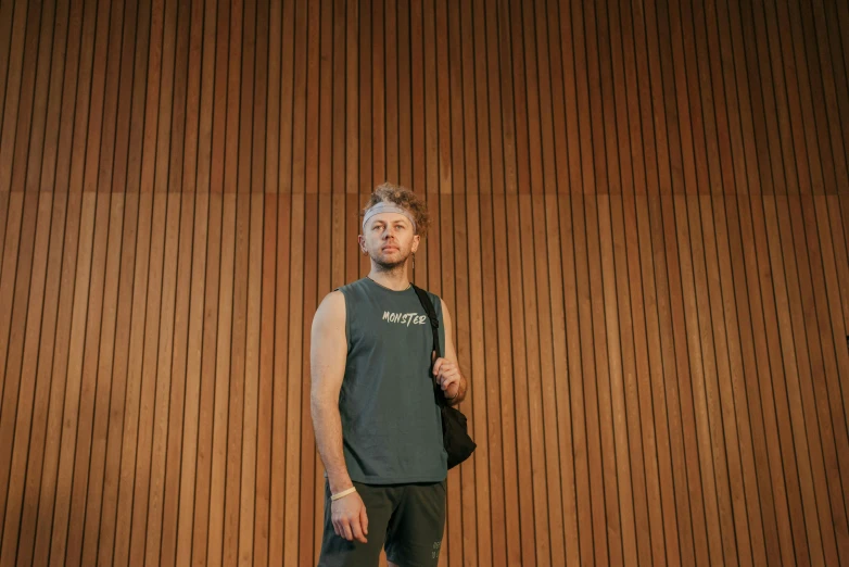 a man standing in front of a wall with wooden walls