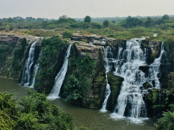 a very tall waterfall is seen in the distance