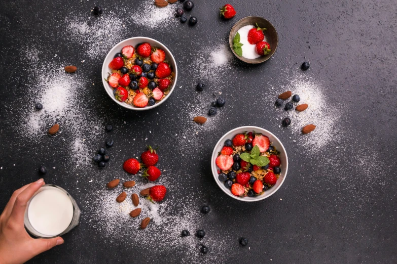 two bowls with various foods in them on a black surface