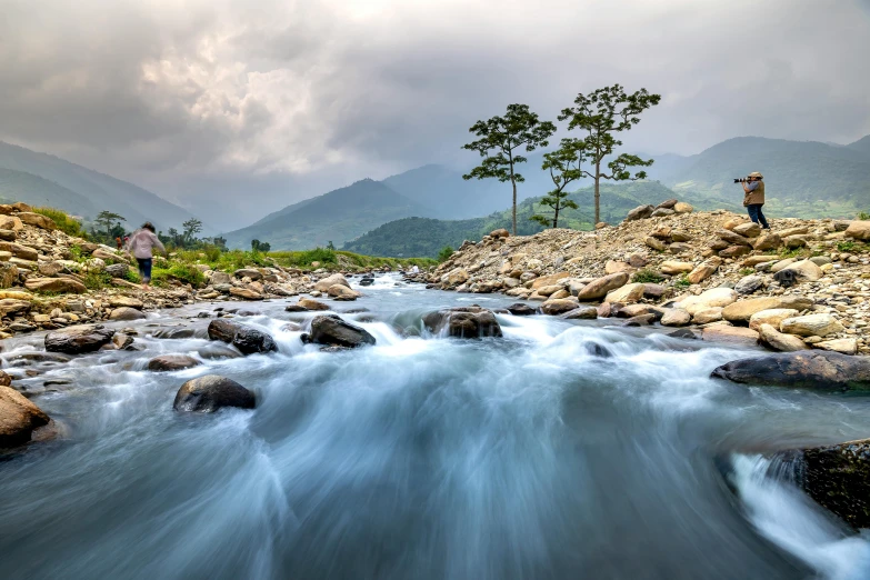 the water is rushing under rocks in the mountain river