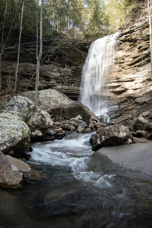 there is a large waterfall with rocks on it