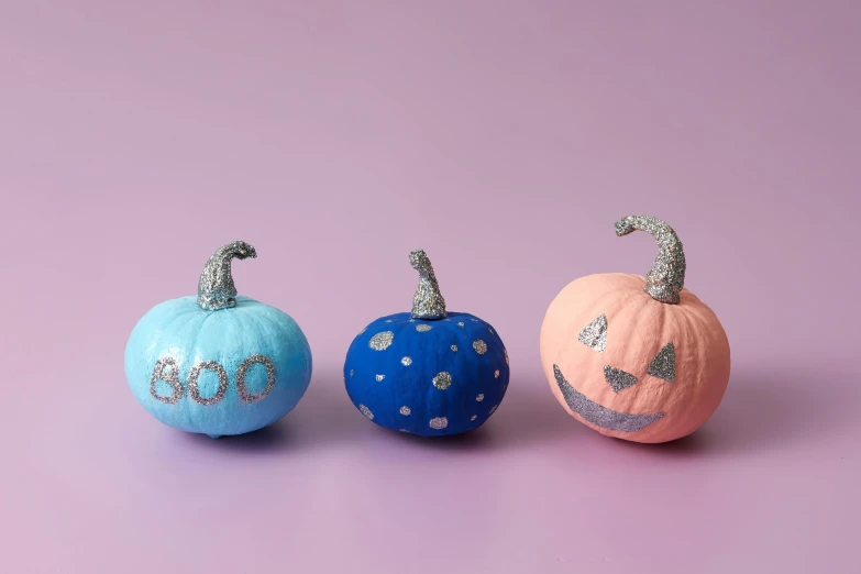 three painted pumpkins with the letters om on them