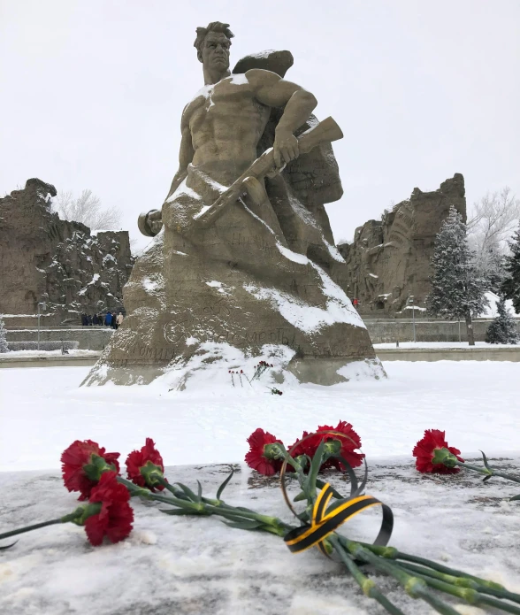 a flower sitting next to a statue with some writing on it