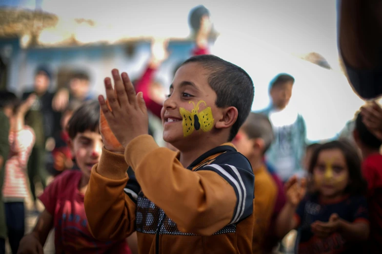 a  with yellow letters painted on his face waves