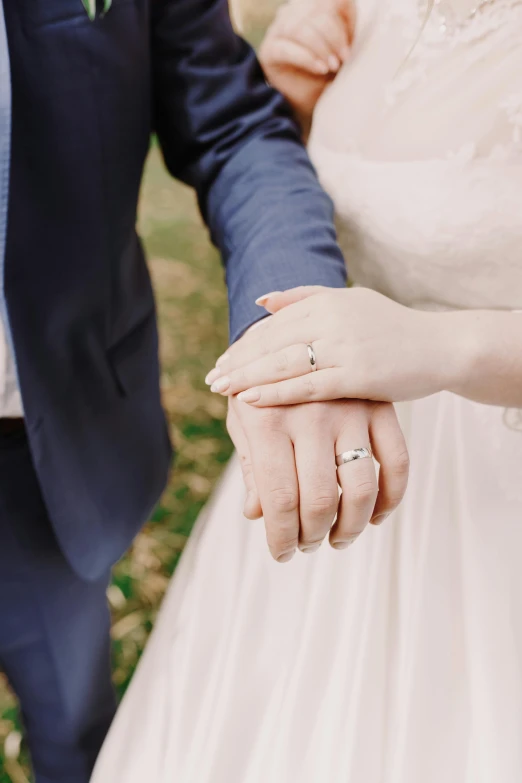 man and woman holding hands walking away from each other