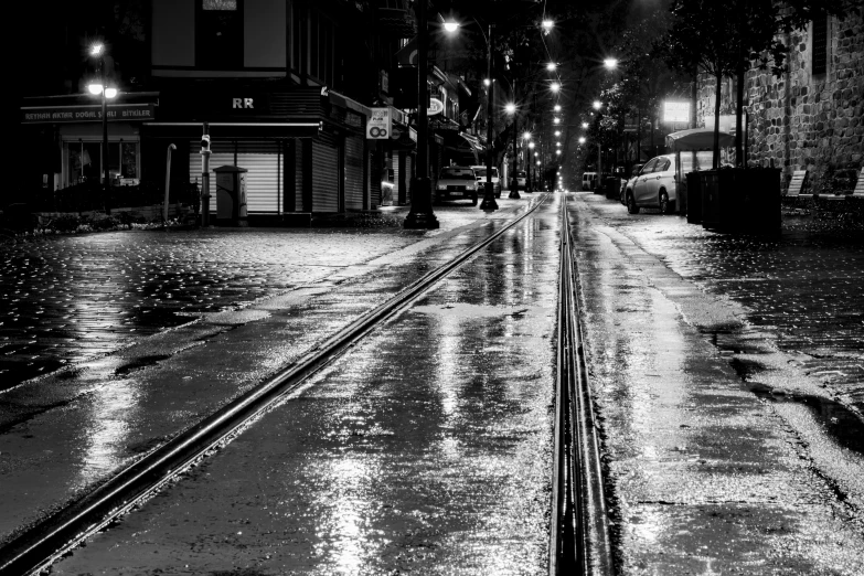 a road with rain falling on it, during the night