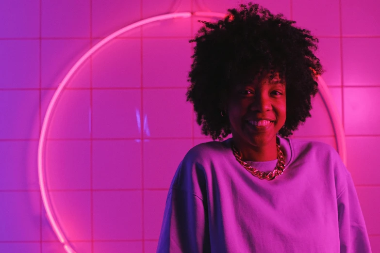a woman standing in front of a pink neon circle