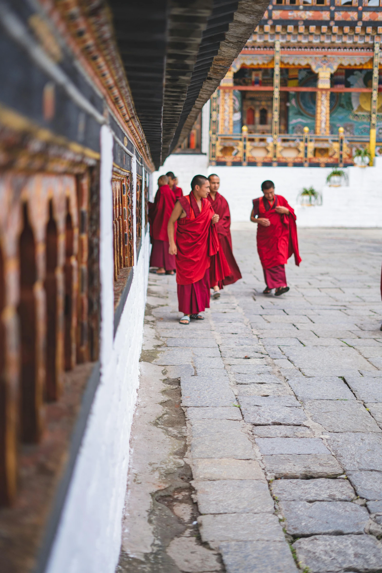 a group of people walking along a stone walkway