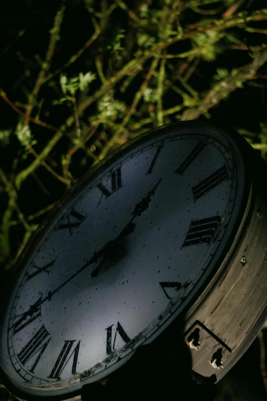 a black clock showing time on an analog powered pedestal