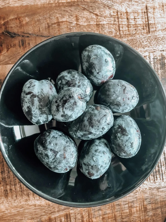 a bowl of chocolate cupcakes on top of a wooden table