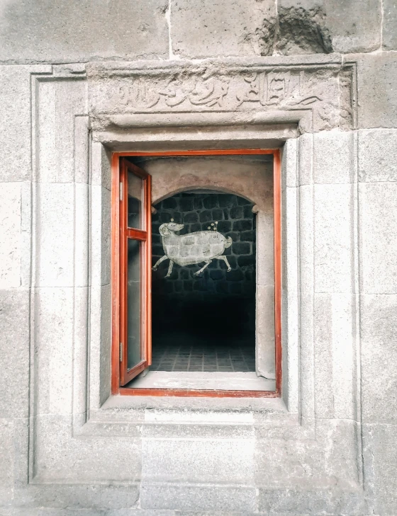 an open window and wall with an image of sheep in a city street