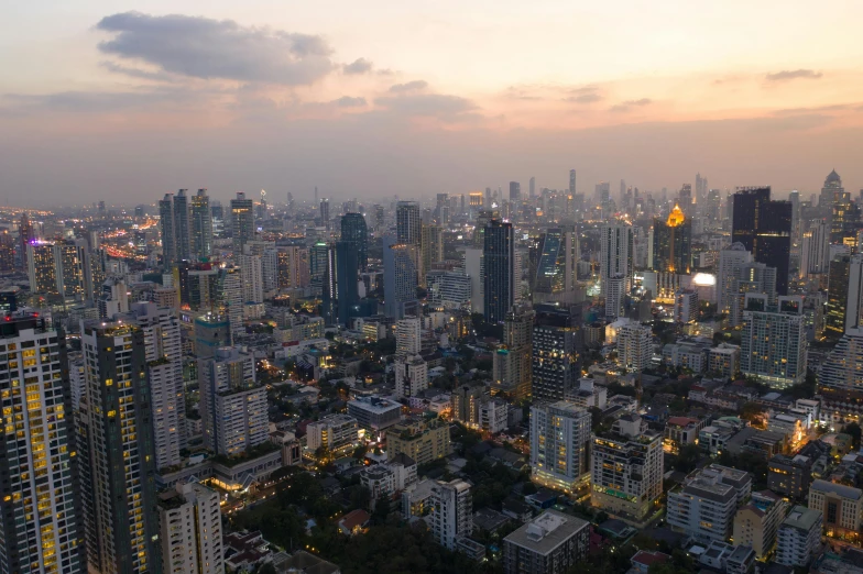 a city from above with lit buildings and cloudy skies