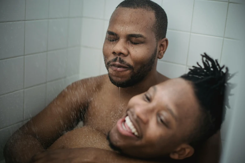 there is a man laughing while another man takes a bath