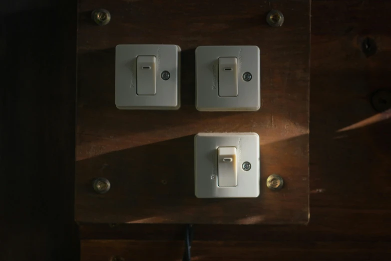 two white light switches on the wall and the rest of the lights