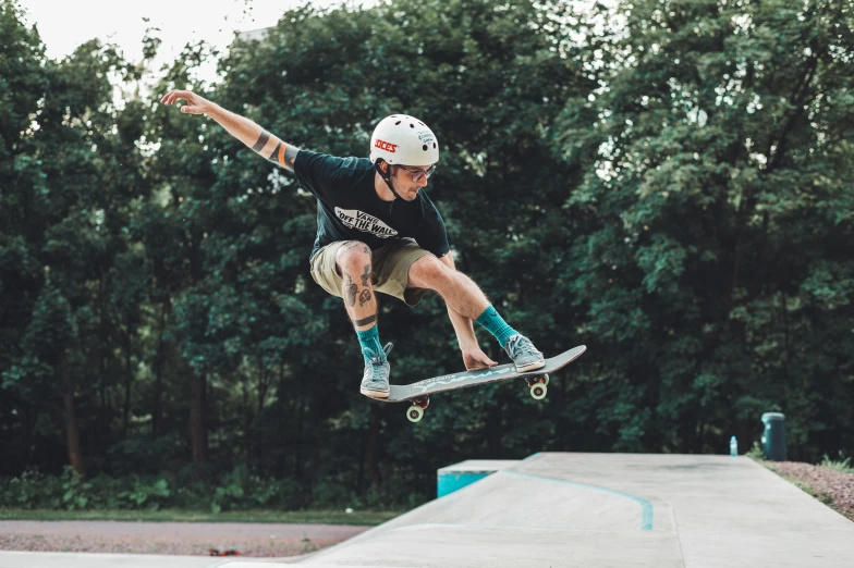 a skateboarder is jumping a ramp while wearing blue shorts