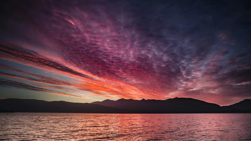 a beautiful sunset over the sea with clouds