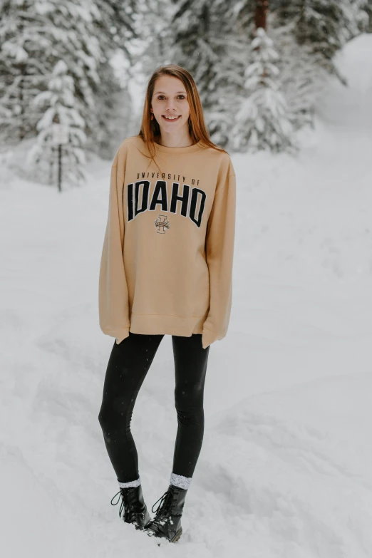 a woman in snow gear standing next to a snowy forest