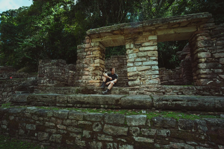 a man sitting in a doorway near some trees