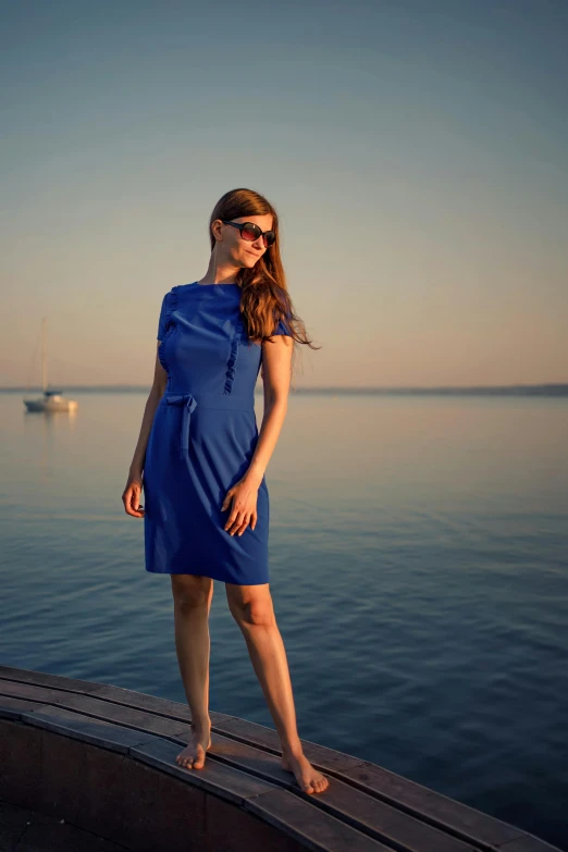 woman in a dress on the edge of a dock