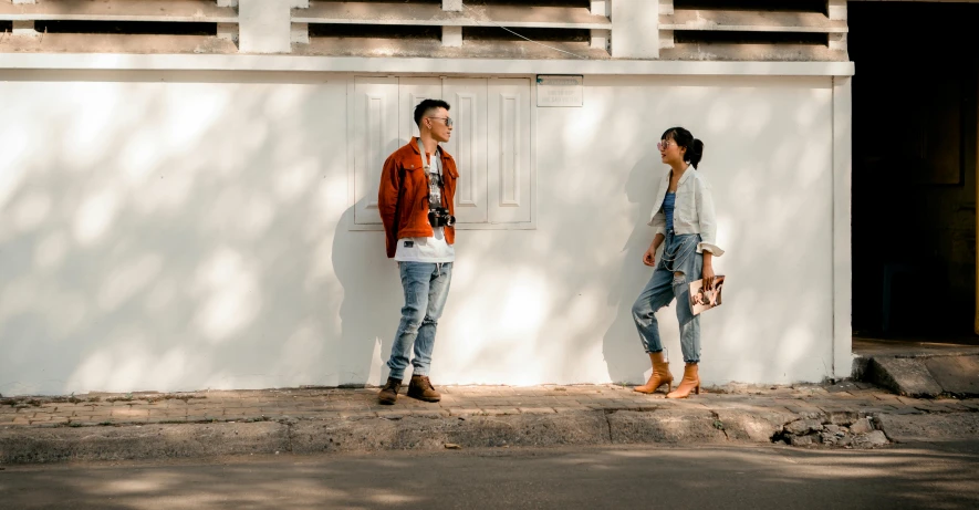 two people standing near each other with a wooden building