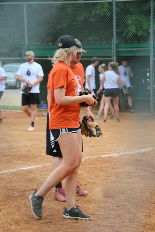 two women in the outfield after playing baseball