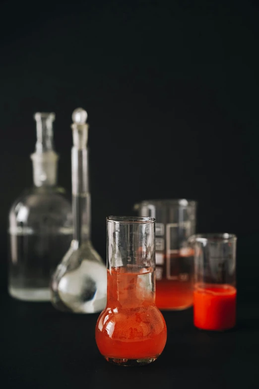 a couple glasses filled with liquid next to bottles