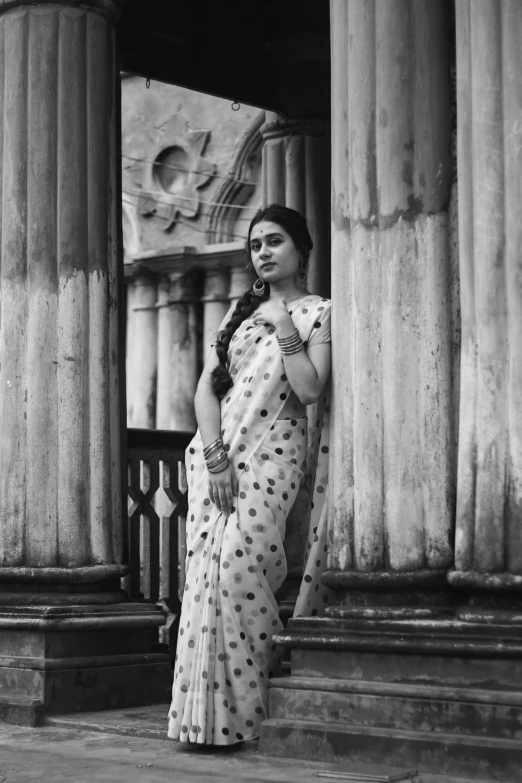 the woman is posing outside of some pillars