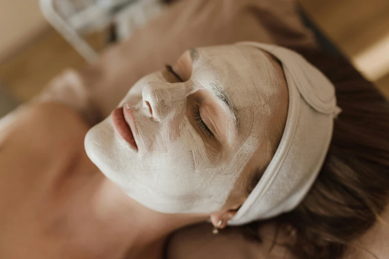 a person lying down with a facial mask on