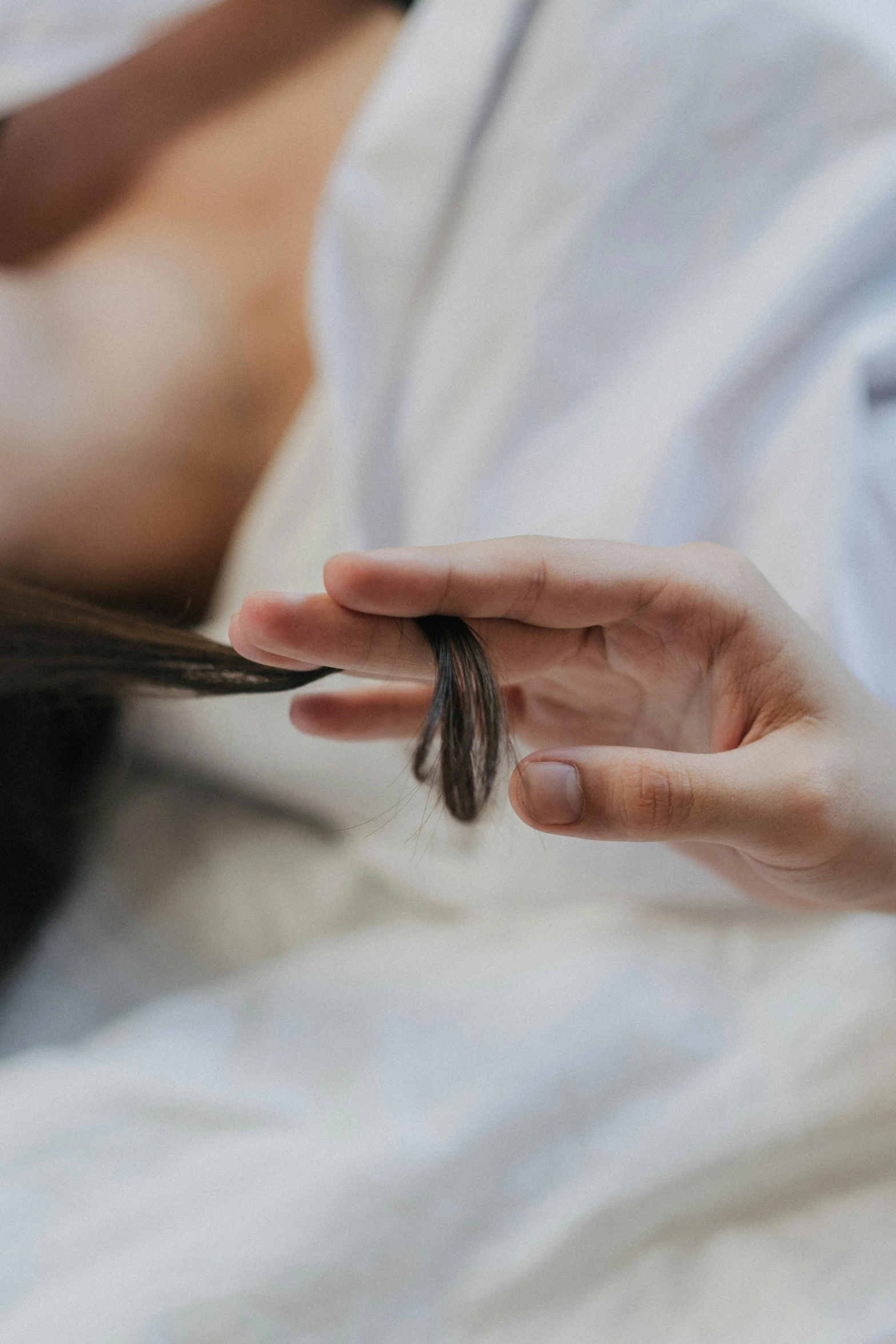 a hand is holding a piece of brown yarn