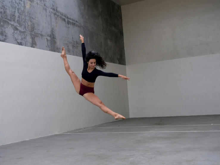 a woman is jumping up in the air while holding on to a pole