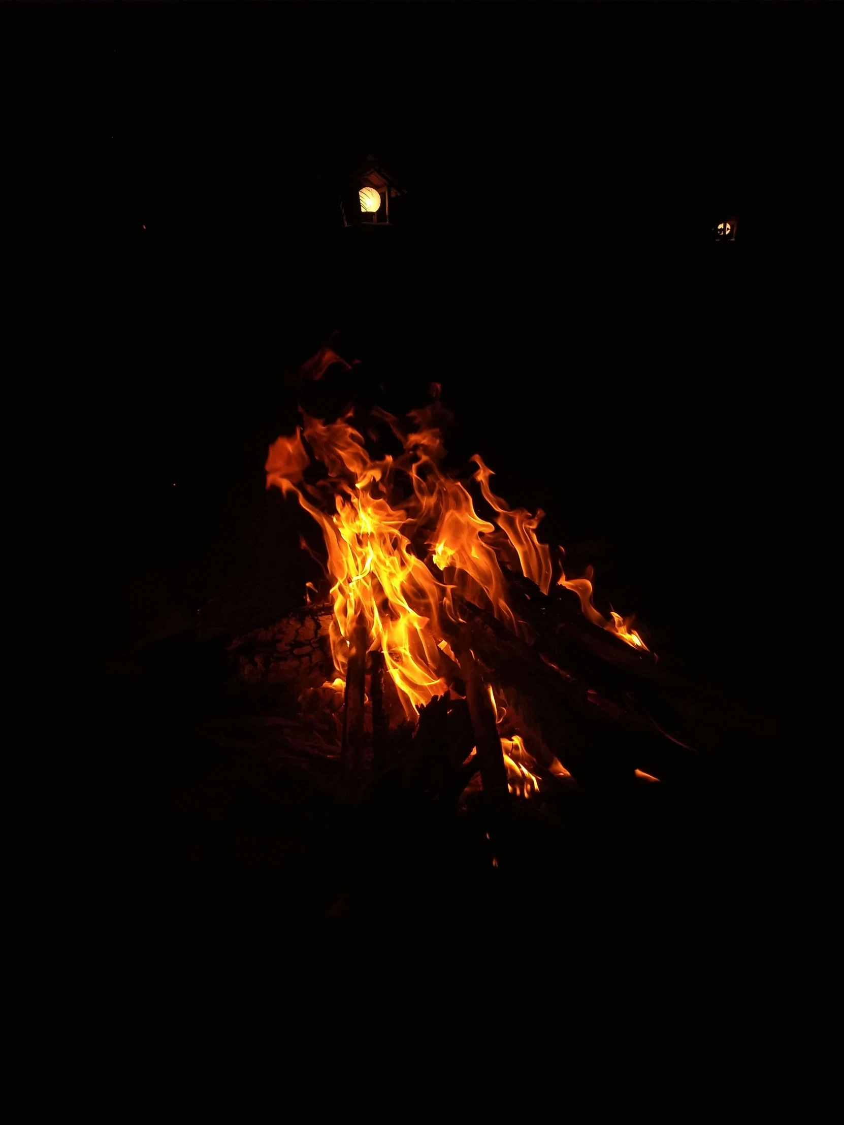 a camp fire with bright flames burning in it
