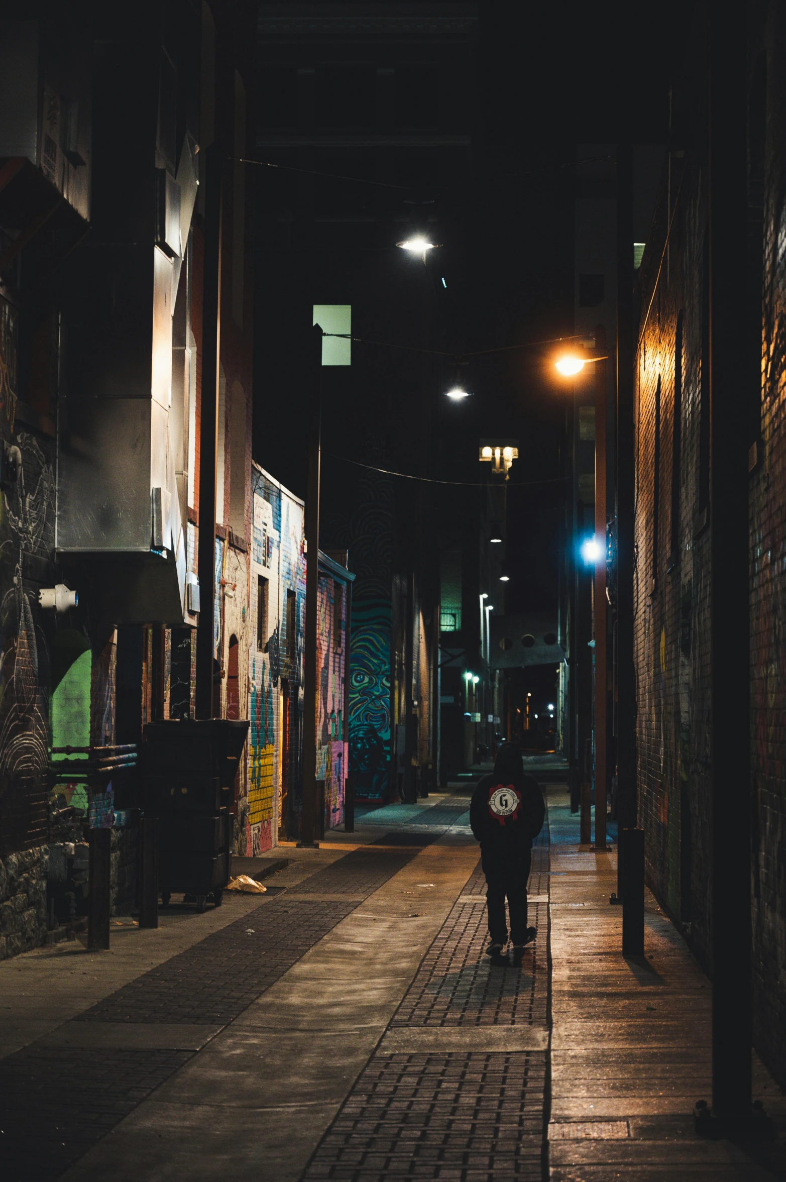 two people walking on a sidewalk at night