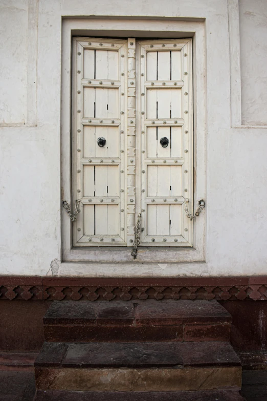 a white building with two large doors leading to it