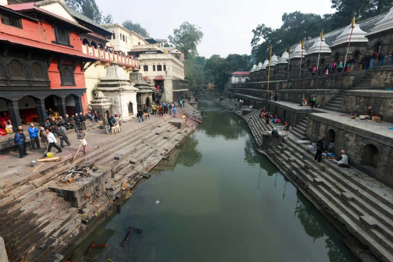 tourists and other tourists stand on the ledges overlooking a canal that flows through the village