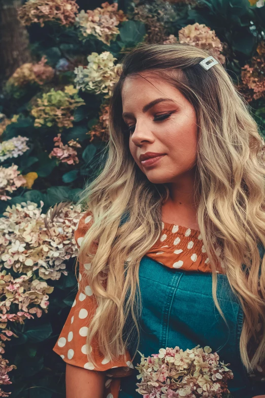 young woman wearing a dress and hair clip surrounded by flowers