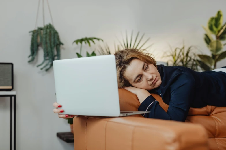 a woman is resting her head on the back of a couch