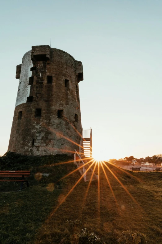 a tower is seen with the sun shining from it