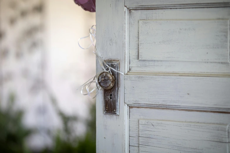 a white door with ribbon and some flowers